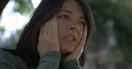 Stressed woman feeling anxiety and distress while rubbing face . Close-up face of female person in...