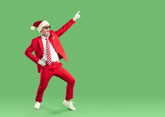 Happy new year guys. Cool man in santa hat having fun, rejoicing and dancing isolated on green...