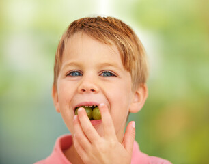 Boy, child or portrait grapes in mouth for health nutrition snack, lunch dessert or vitality development. Male, kid or fruit face for happy eating outdoor summer food, nature picnic or fibre minerals