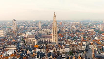 Fotobehang Antwerp, Belgium. Spire with the clock of the Cathedral of Our Lady (Antwerp). Historical center of Antwerp. City is located on river Scheldt (Escaut). Summer morning, Aerial View © nikitamaykov