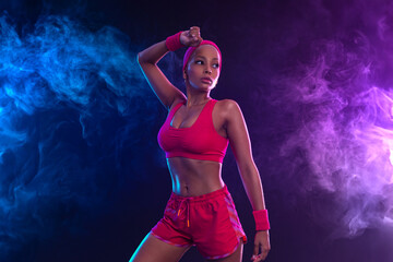 Sporty fit woman, athlete after fitness exercises on black background. Download cover for music collection for fitness classes. Sports recreation. Beautiful black young woman.