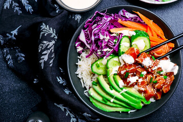 Salmon poke bowl with vegetables and avocado.top veiw
