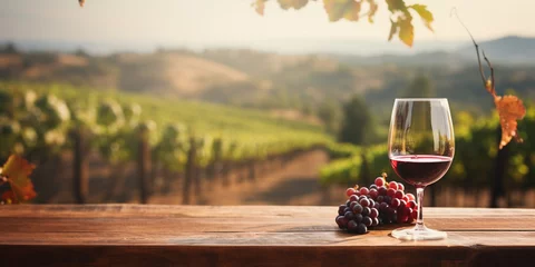 Foto op Canvas Wood table top with a glass of wine on blurred vineyard landscape background © Ricardo Costa