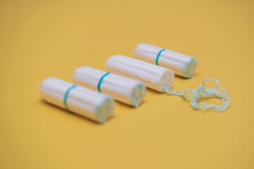 Medical female cotton tampon on a yellow background. Hygienic white tampon for women. Cotton swab. Menstruation, means of protection