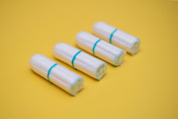Medical female cotton tampon on a yellow background. Hygienic white tampon for women. Cotton swab. Menstruation, means of protection