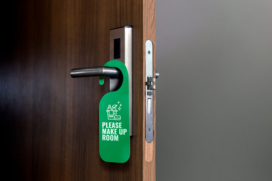 Please make up room. Sign hanging on doorknob. Hotel tag for bedroom door.