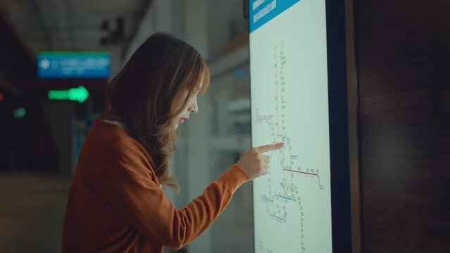 Asian woman pointing on the railway map .Find the route of railway in main station, Tourist journey trip concept