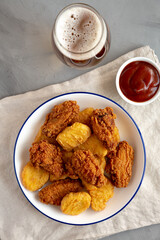 Homemade Chicken Nuggets and Chicken Wings with Ketchup and Beer, top view.