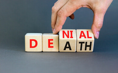 Denial death symbol. Concept words Denial Death on wooden block. Beautiful grey table grey background. Businessman hand. Business denial death concept. Copy space.