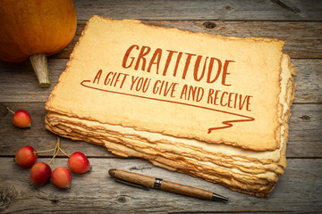 gratitude - a gift you give and receive, Thanksgiving holiday theme, handwriting on a rough...