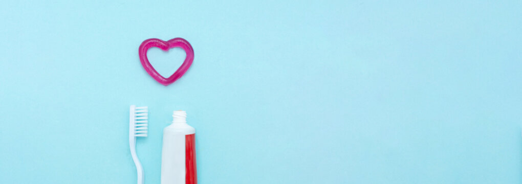 Closeup of a toothpaste, toothbrush and toothpaste heart on blurred blue background.Professional Dental concept.