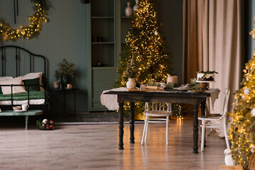 Dining table with festive serving and decor for Christmas in a cozy living room interior with a...