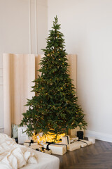 Christmas tree with gifts in the interior of a stylish modern bedroom