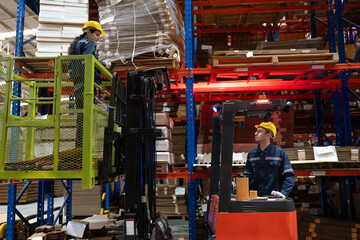 Caucasian businesswoman workers checking stock while standing on scissor lift with Caucasian...