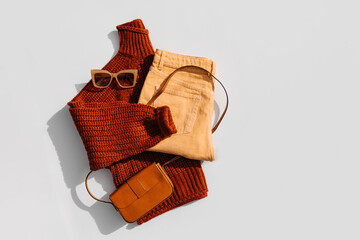Knitted brown sweater with pants and handbag. Women's warm jumper, stylish autumn or winter clothes. Fashion autumnal outfit. Cozy bright  fall look. Flat lay, top view.
