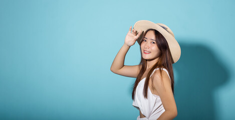 Asian young woman hand up cover face protect sun light and UV smile in studio shot isolated on blue...