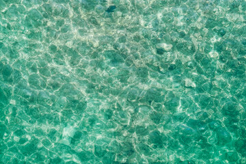 Sea. Emerald water surface, pebbles on the bottom. Natural background. Shooting from a drone.