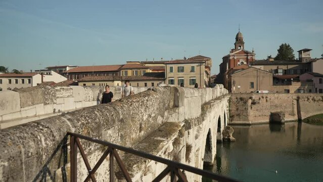 View of people crossing Ponte di Tiberio in Rimini, Rimini, Emilia Romagna, Italy