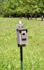 A close view on the old box wood birdhouse in the field.