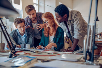 Young and diverse group of architects working on a project together in a startup company office