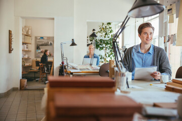 Happy young designer working in a office