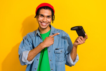 Photo of eccentric funky cheerful guy wear denim shirt demonstrates playstation game isolated on yellow color background