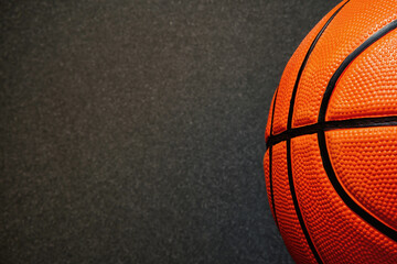 Banner with half of official orange leather basketball and dark black floor surface. Streetball and hoops. Copy space for text - obrazy, fototapety, plakaty
