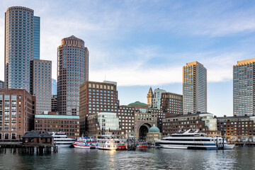 Fototapeta premium Embankment with moored ferries and other ships and boats in the center of the downtown of old Boston with skyscrapers