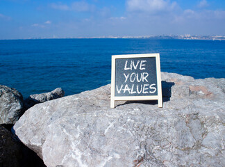 Live your values symbol. Concept words Live your values on chalk blackboard. Beautiful sea...