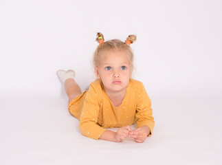 Pretty little girl lays on the floor and thinks about something