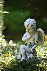 A small, white sandstone sculpture of an angel on a cemetery in Weimar-Germany.