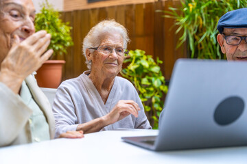 Obraz premium Seniors learning how to use a laptop in a geriatric