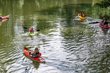 Group of amateur kayakers prefer an active lifestyle and travel in kayaks on the mirror-like surface of a forest lake