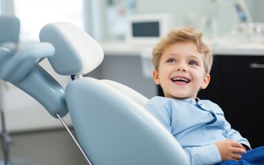 A happy child sitting in the dental chair at a dentist - obrazy, fototapety, plakaty