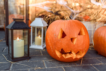 Sunny Halloween Day with a Carved Pumpkin and Glowing Lanterns on a Sidewalk