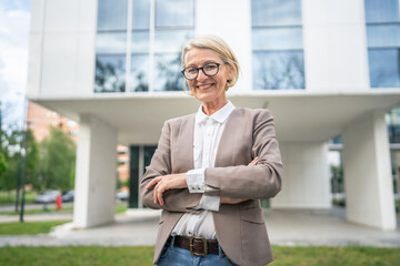 Portrait of one caucasian blonde mature businesswoman stand outdoor