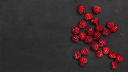 Saftige Himbeeren auf dunklem Tisch: Ein gesunder und farbenfroher Genuss.