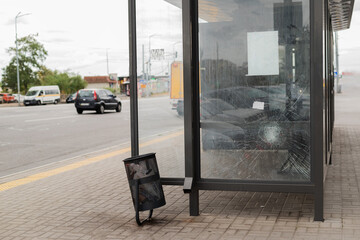 Broken glass at the bus stop. Public transport station vandalised by the glass windows. cracks of...