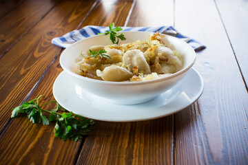 Ukrainian Vareniky or Pierogi stuffed with potato and mushrooms, served with fried onion.