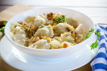 Ukrainian Vareniky or Pierogi stuffed with potato and mushrooms, served with fried onion.