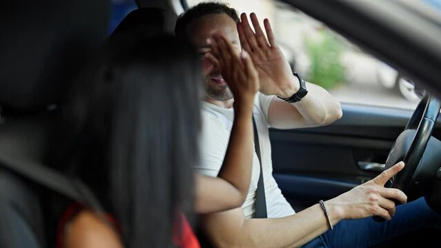 Beautiful couple smiling confident driving car high five at street