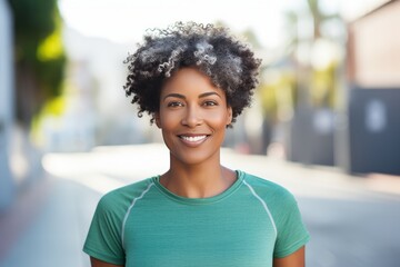 Cheerful adult African American woman 45-50 years old on a morning jog around the city, playing sports in her old age, health prevention, outdoor training