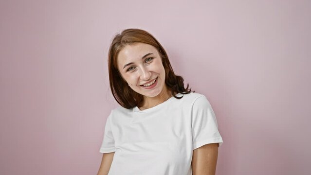 Young woman pointing to the camera winking eye smiling over isolated pink background