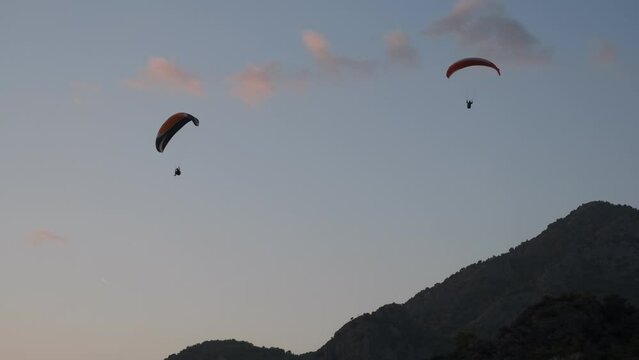 Multi-coloured paragliders circling in the blue sky. Paragliding is the recreational and competitive adventure sport of flying paragliders. &Ouml;l&uuml;deniz, Fethiye, T&uuml;rkiye
