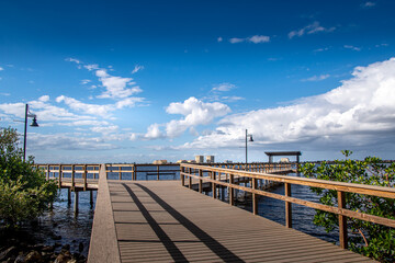 Scenes along Bradenton Florida Riverwalk East, boardwalk, wooden pier, structures, park and nature scenes, wooden observation tower, Manatee River. Blue skies white full clouds. Florida nature scene