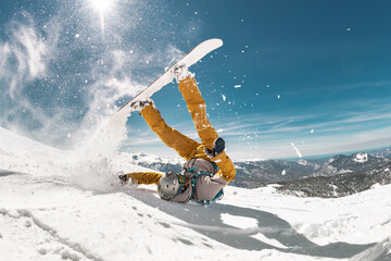 Real snowboarder falls at offpiste ski slope. ski safety concept - obrazy, fototapety, plakaty