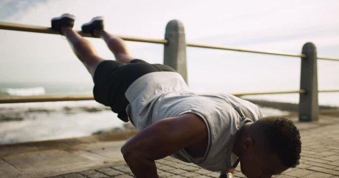 Black man, push up and exercise at the beach for fitness or training outdoor for challenge in workout goals. African, person and balance on fence at ocean for health, wellness and growth in muscle