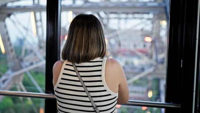 Young beautiful hispanic woman riding in big wheel looking at the views at Prater Vienna