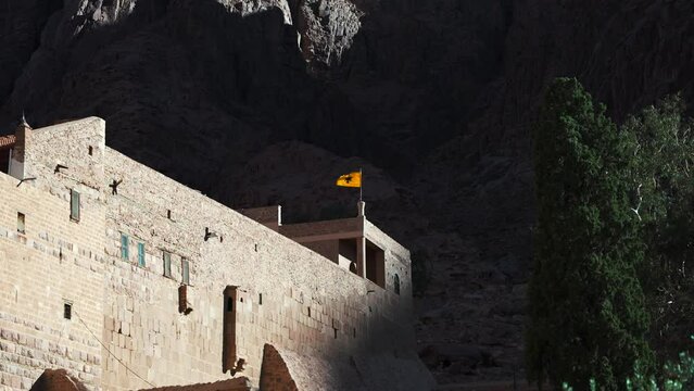 Flag with the two-headed eagle of the Byzantine empire in Saint Catherine Monastery roof. Ancient historical religious place at Mount Sinai. Tourist excursion to the Mountain of Moses