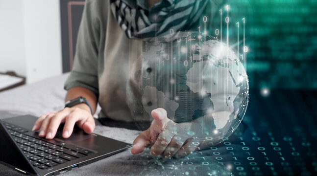 Mujer trabajando en su laptop desde su casa, aprovechando la tecnolog&iacute;a, adaptada a un mundo globalizado. Globo terr&aacute;queo rodeado de ceros y unos. Su dedo toca el mundo digital.